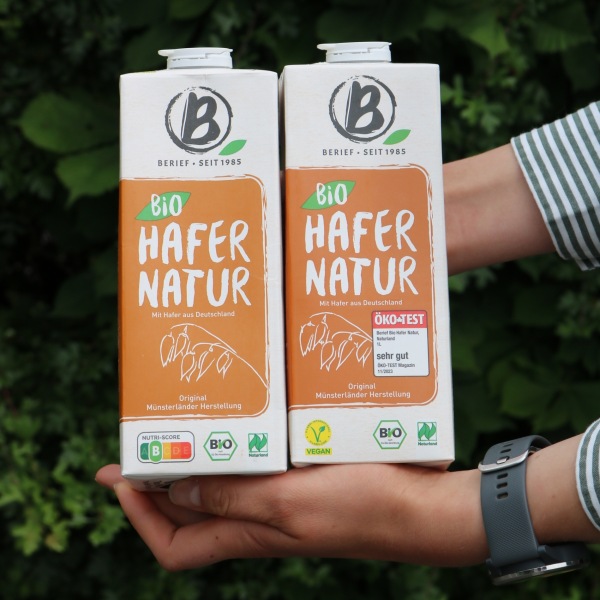 Nutriscore verschwindet Jemand hält zwei Hafergetränkekartons in den Händen.
