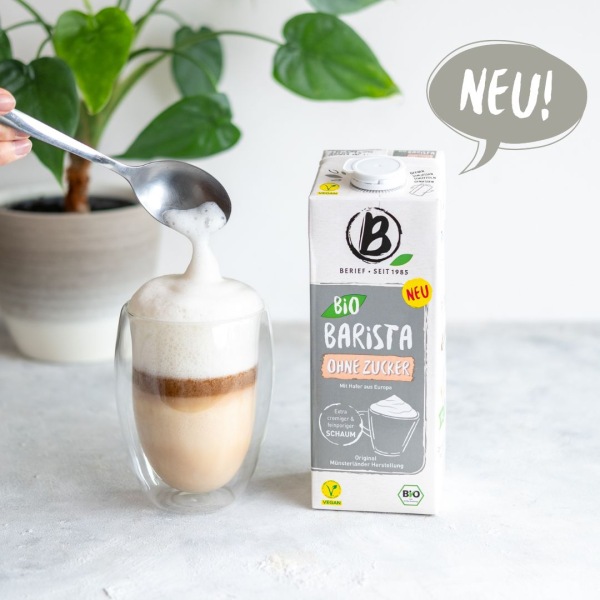 Neu Bio Barista ohne Zucker Eine Getränkepackung steht neben einem Cafe Latte vor weißem Hintergrund