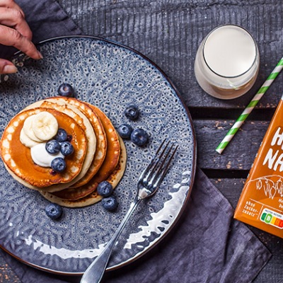 Vegane Blaubeer-Pancakes Pancakes auf einem blauen Teller ganiert mit Blaubeeren