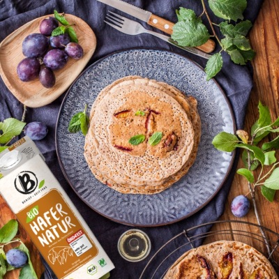 Pfannkuchen mit Pflaumen vegan Pfannkuchen auf einem blauen Teller mit Pflaumen