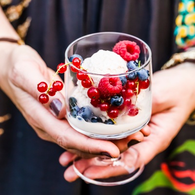 Schokoladeneis mit Beeren Ein Glas mit Eis und bunten Beeren