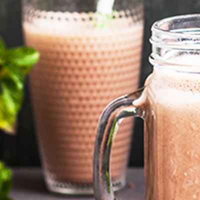 Schoko-Minz-Eisshake Schokofarmbenes Shake in zwei Gläsern mit Trinkhalm