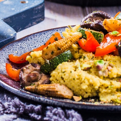 Creamy Couscous mit mediteranem Grillgemüse Couscous mit Gemüse auf einem blauen Teller