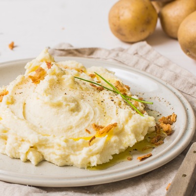 Klassischer Kartoffelbrei Kartoffelpüree mit Kräuter-Topping auf einem weißen Teller