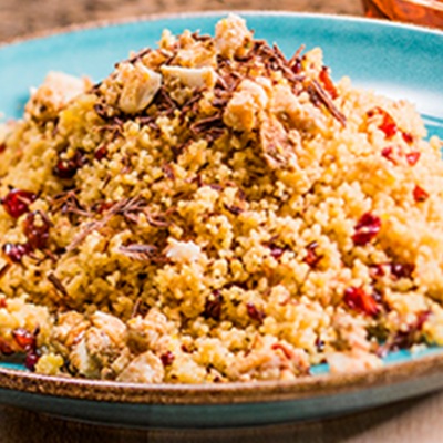 Süßer Cranberries-Couscous Cranberries-Couscous auf einem blauen Teller