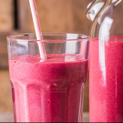 Himbeeren-Mandel-Chia-Smoothie Hellrotes Smoothie in einem Glas mit Strohhalm