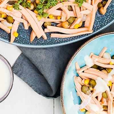 Vegane Mayonnaise Fleischsalat angerichtet auf zwei Tellern mit Gemüse und Mayonnaise.