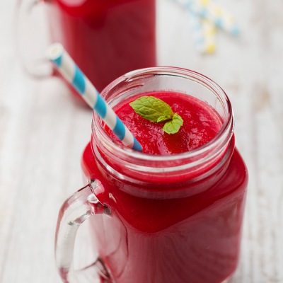 Rote_Bete-Erdbeer-Orange-Smoothie Rotes Getränk in einem Glas mit Strohhalm