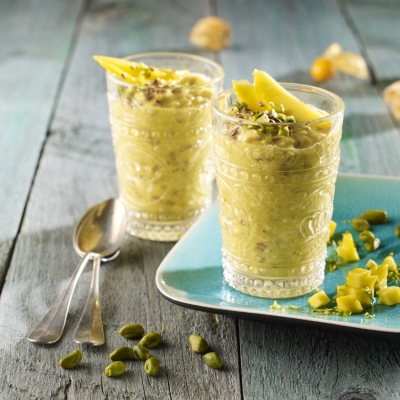Mango-Porridge mit Kurkuma Hellgelbes Getränk in zwei Gläsern auf einem Tisch mit Dekoration